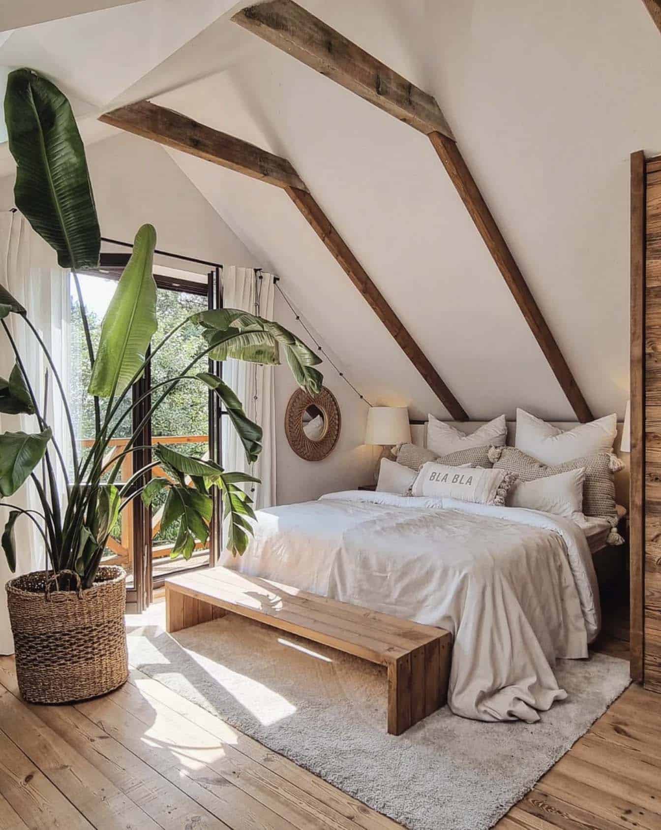 cozy bedroom with a tall ceiling filled with natural light and a large plant