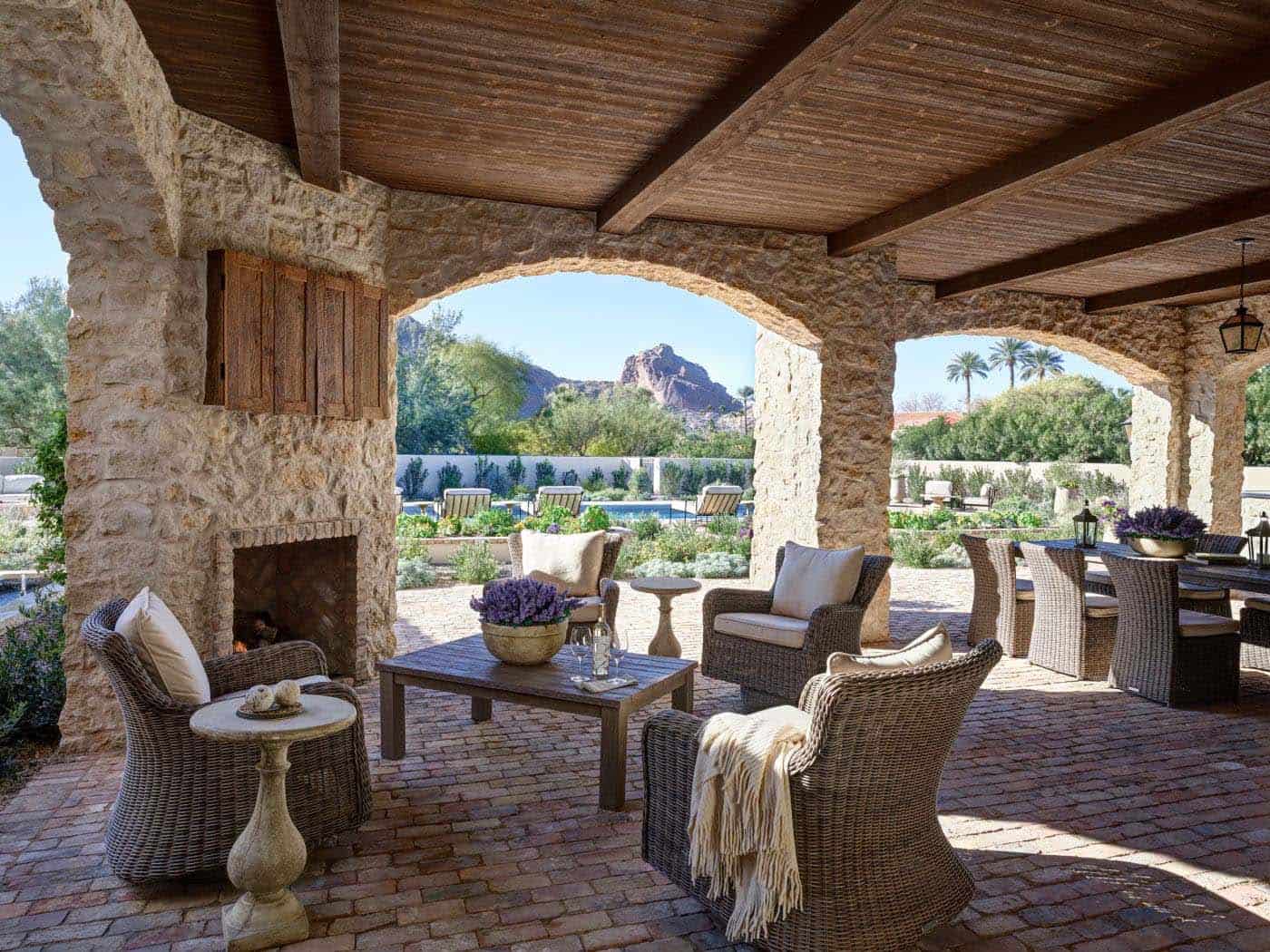 mediterranean style covered patio with a fireplace