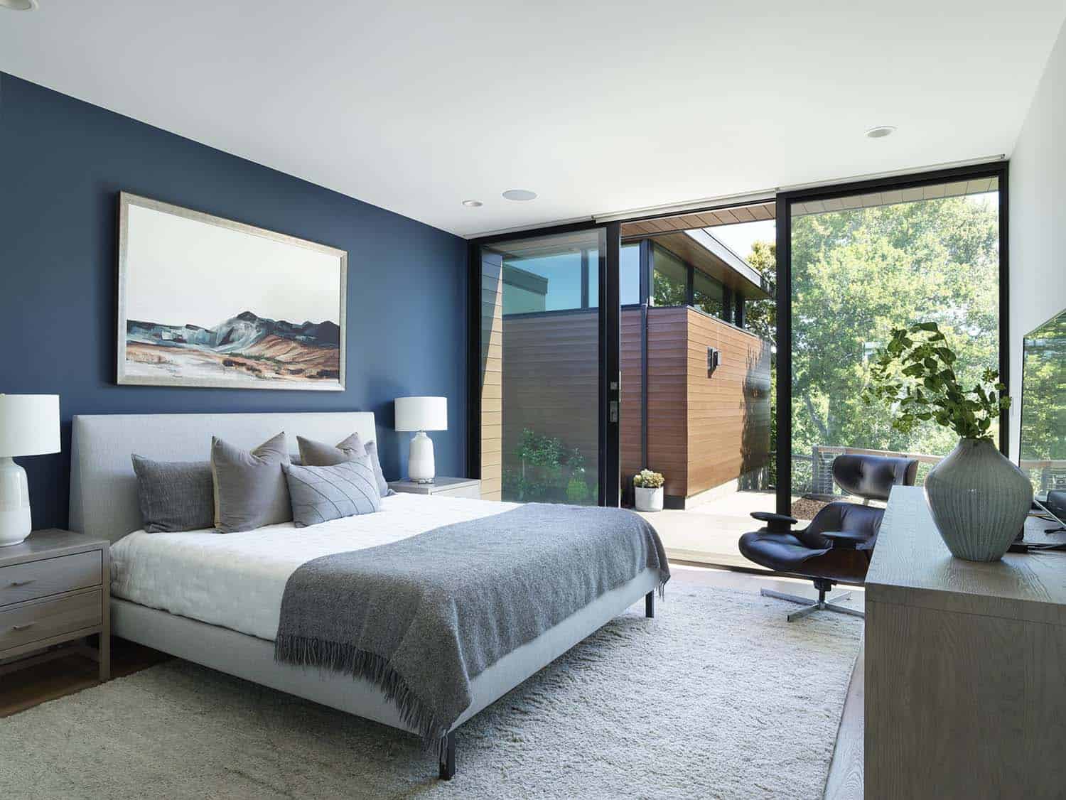 modern contemporary bedroom with a sliding glass door leading out to a private patio