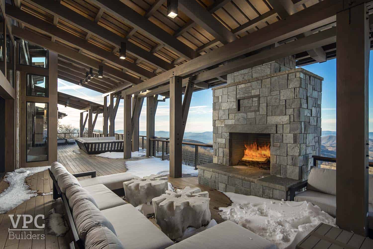 modern mountain lodge covered patio with a fireplace