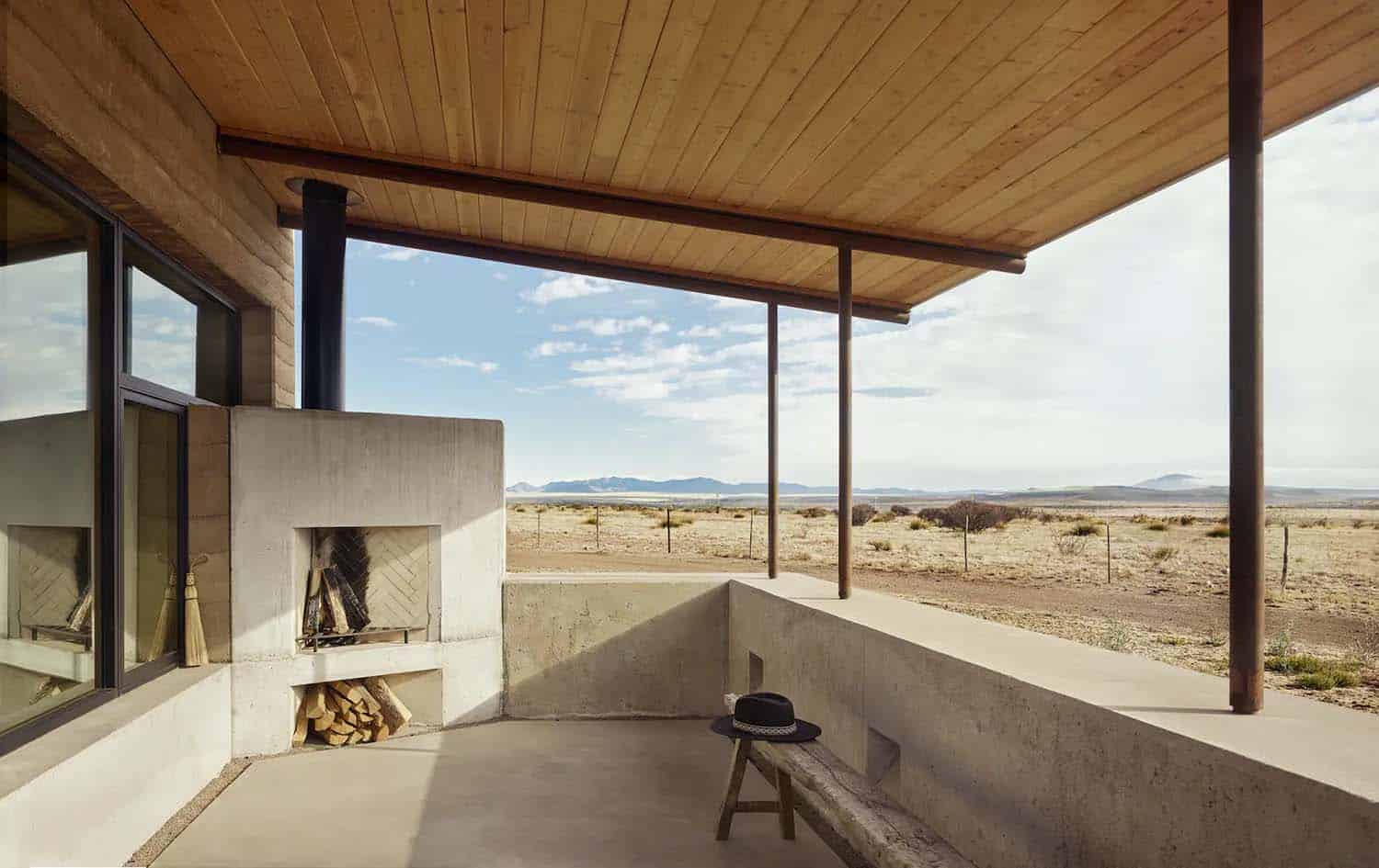 rammed earth ranch house covered porch with a fireplace