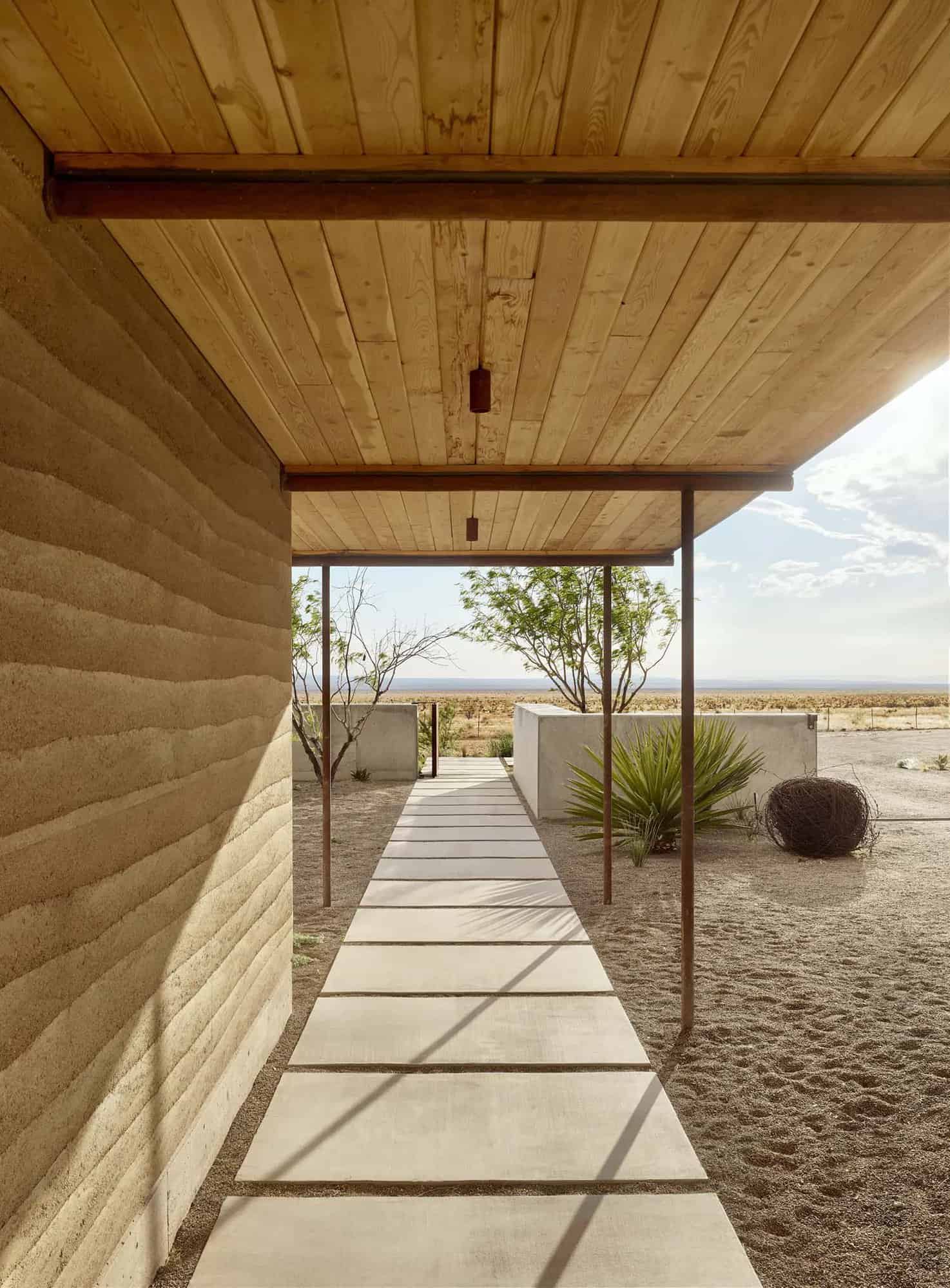 rammed earth ranch house covered pathway