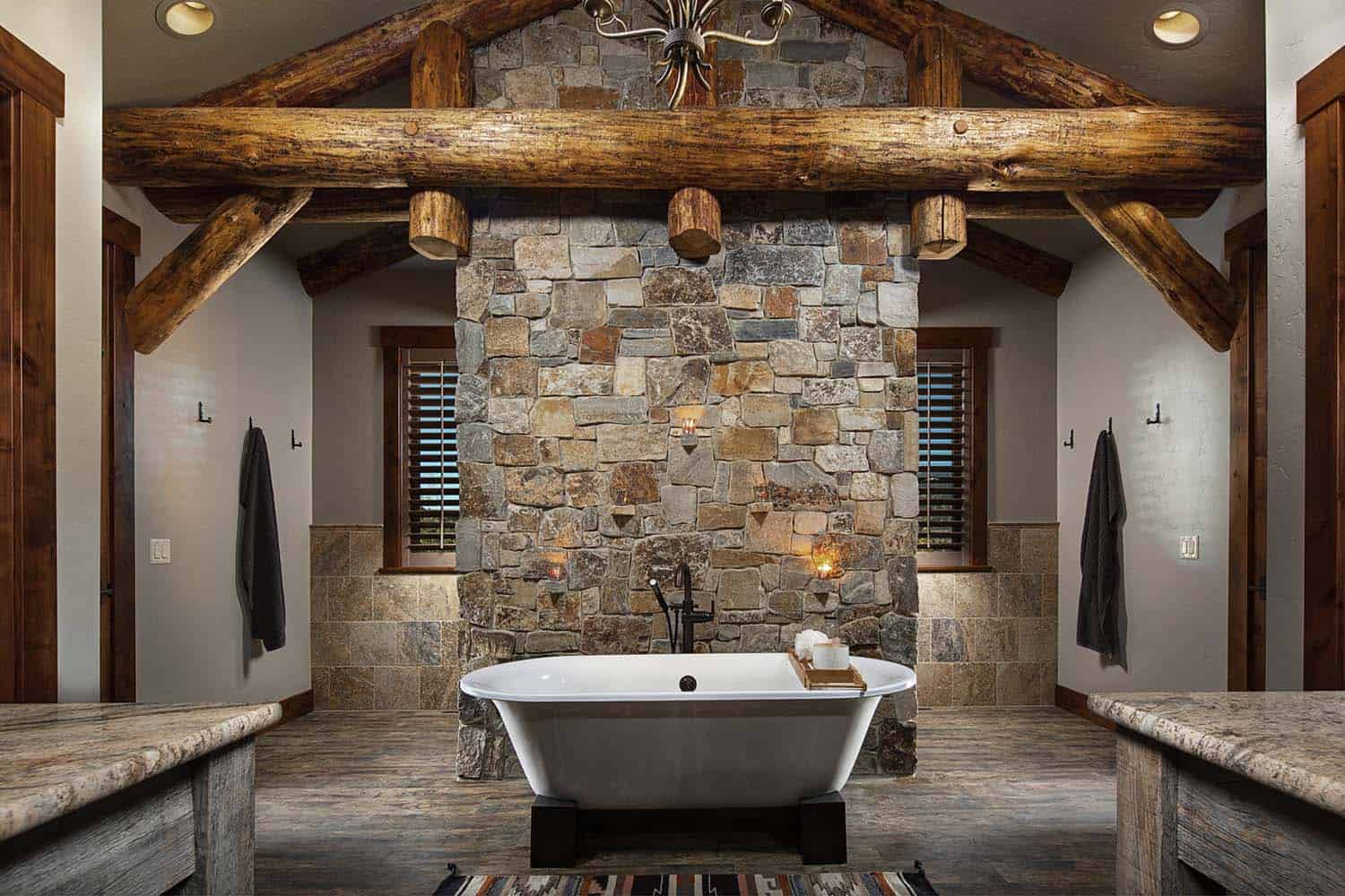 rustic bathroom with a soaking tub and stone wall