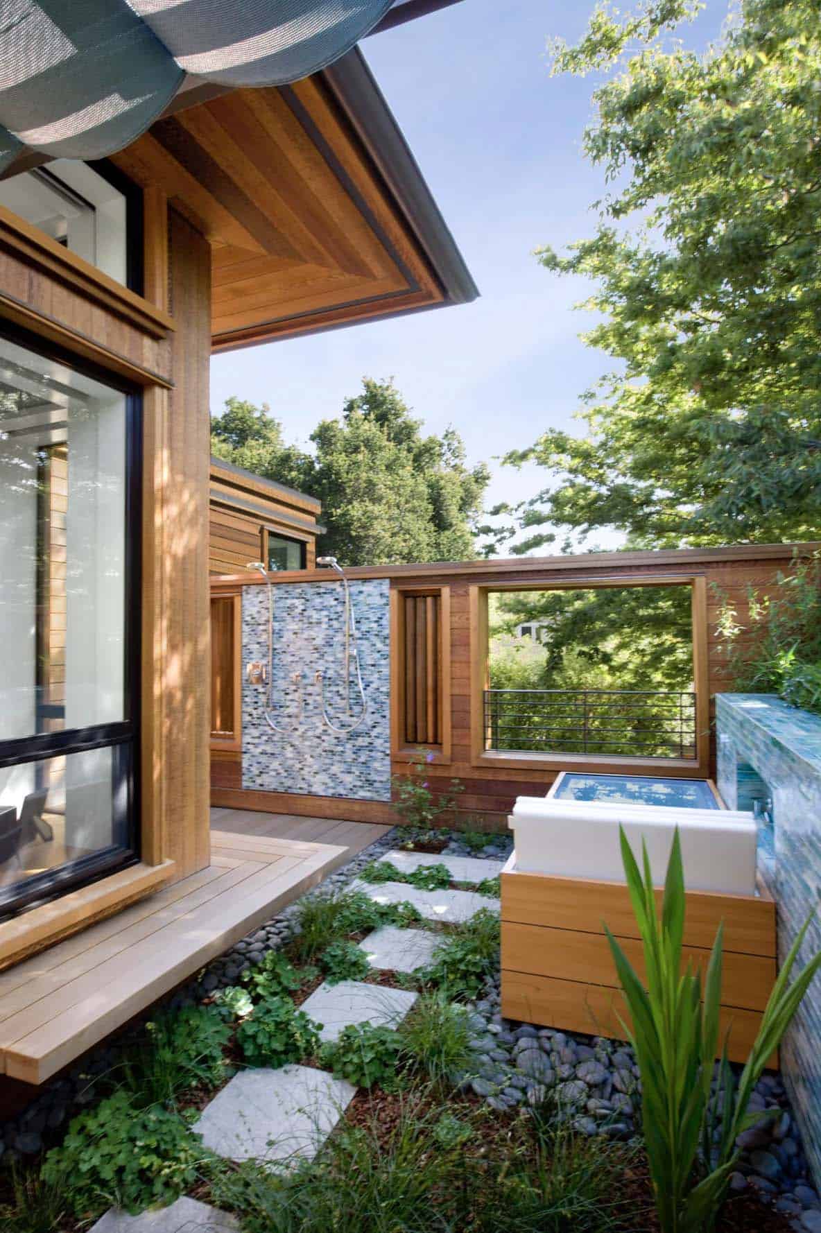 second-floor deck with outdoor shower + tub, living roof, and built-in bench