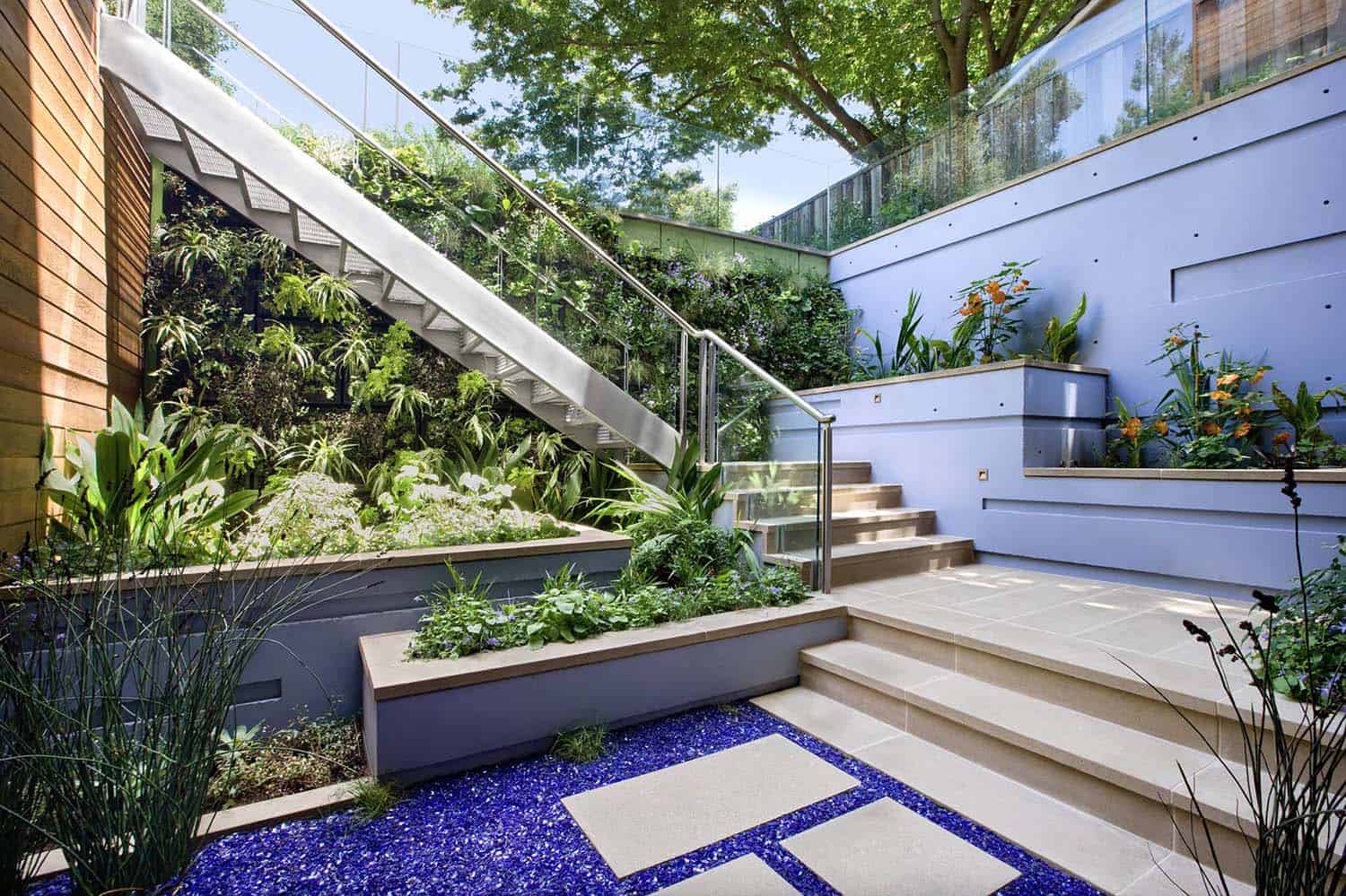 exterior stair to below-grade patio and garden with planted green walls and built-in planters