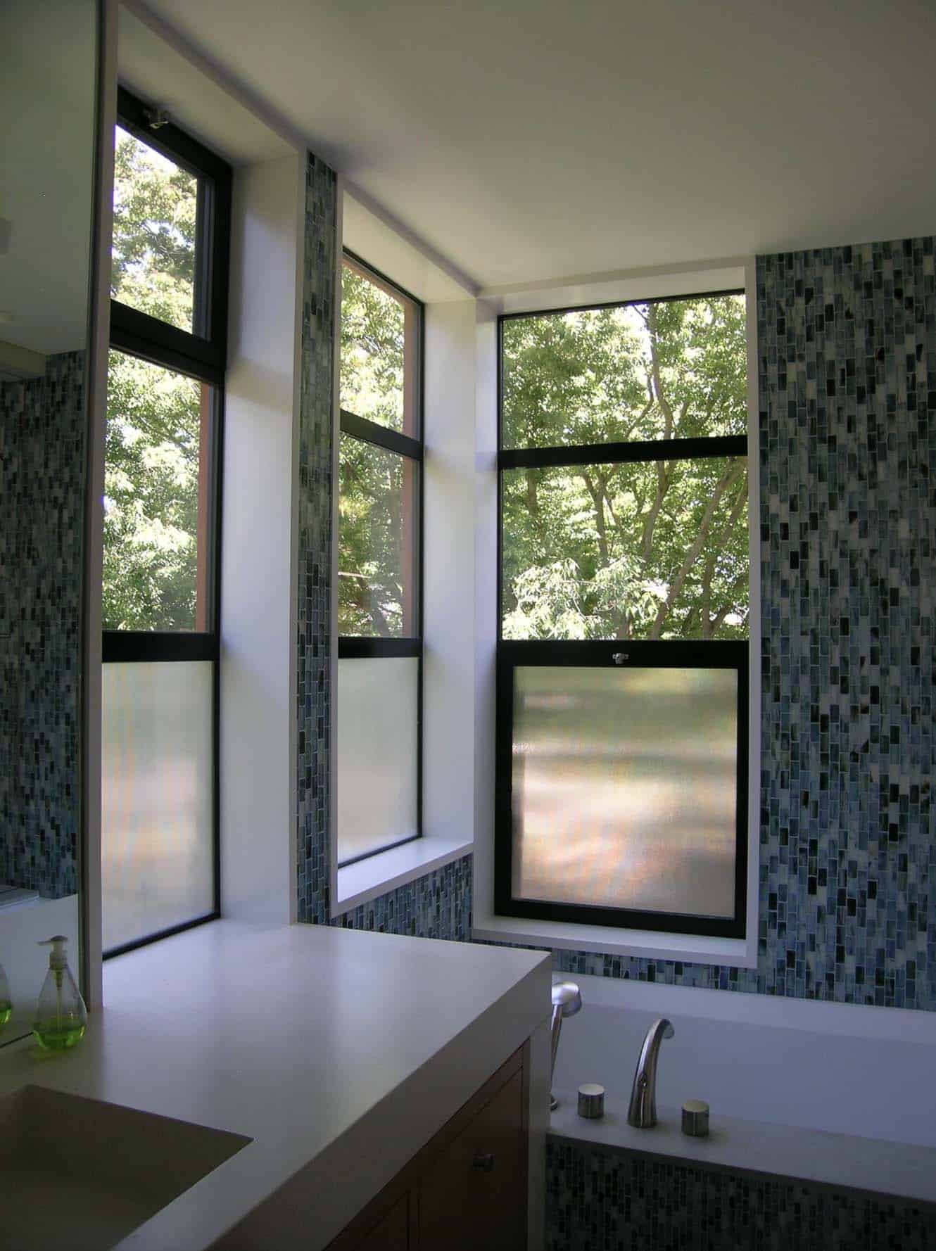 bathroom with a corner window with clear and translucent glass