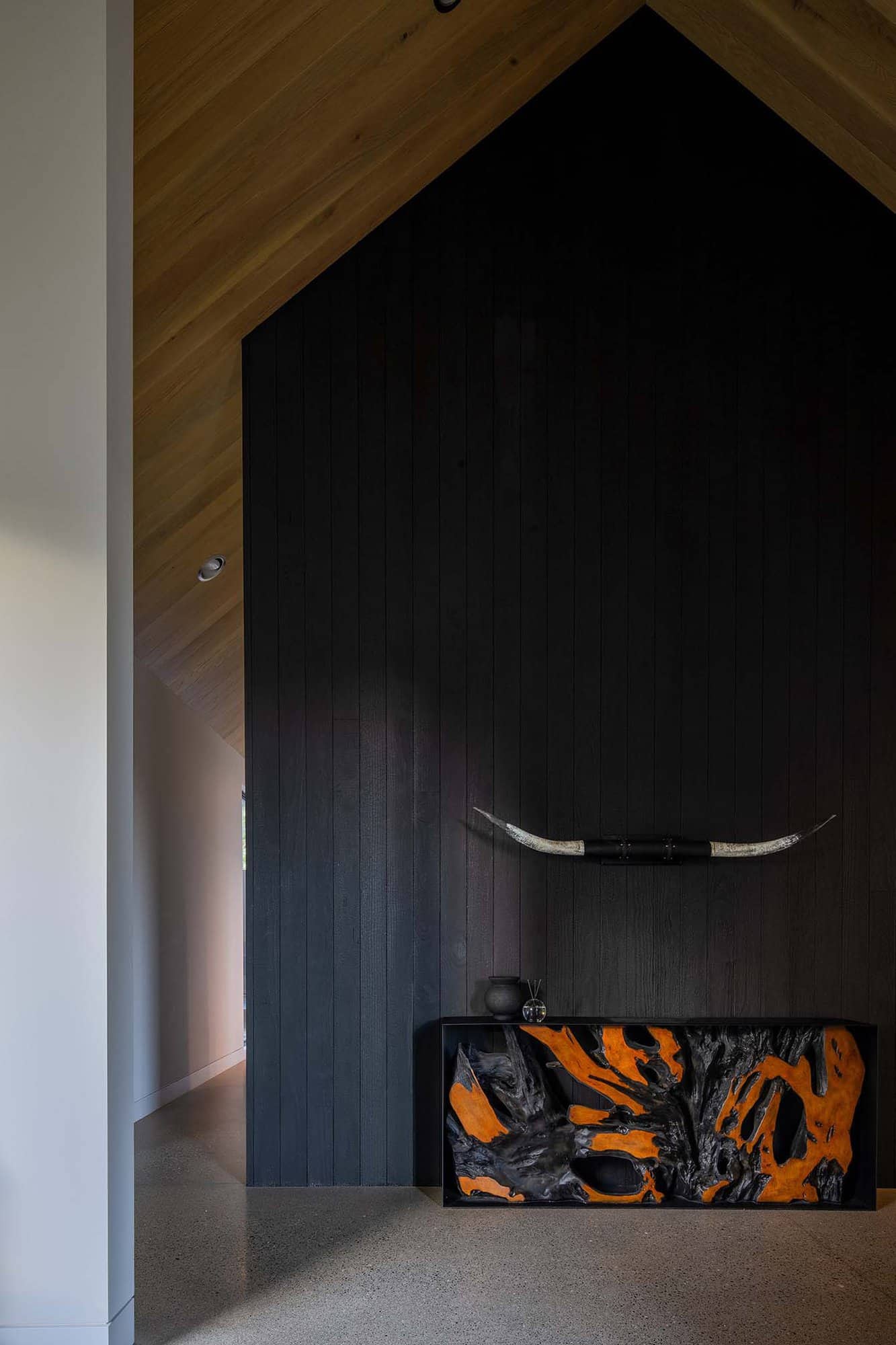 contemporary console table with a black wood siding backdrop