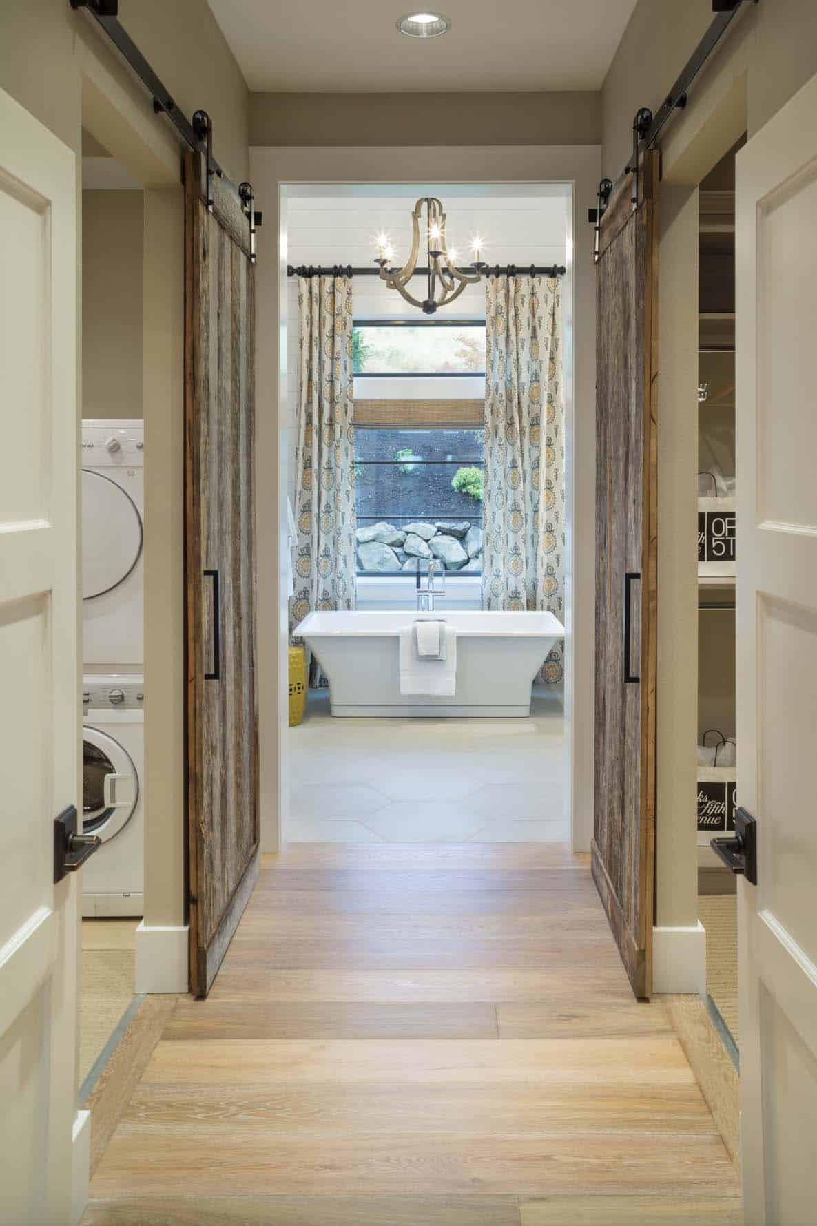 transitional style bedroom hallway with a washer/dryer leading to the bathroom