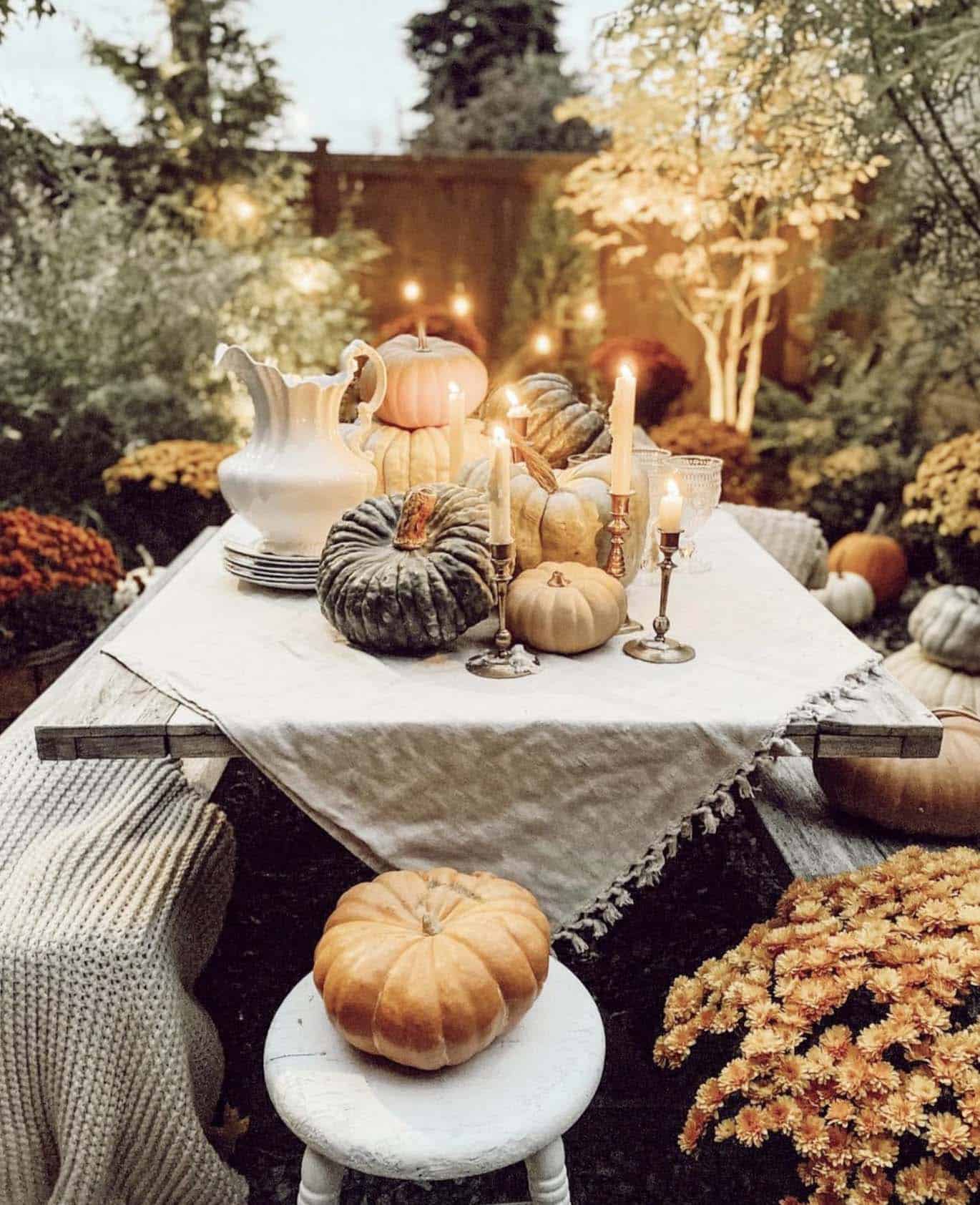 outdoor fall tablescape with pumpkins and mums
