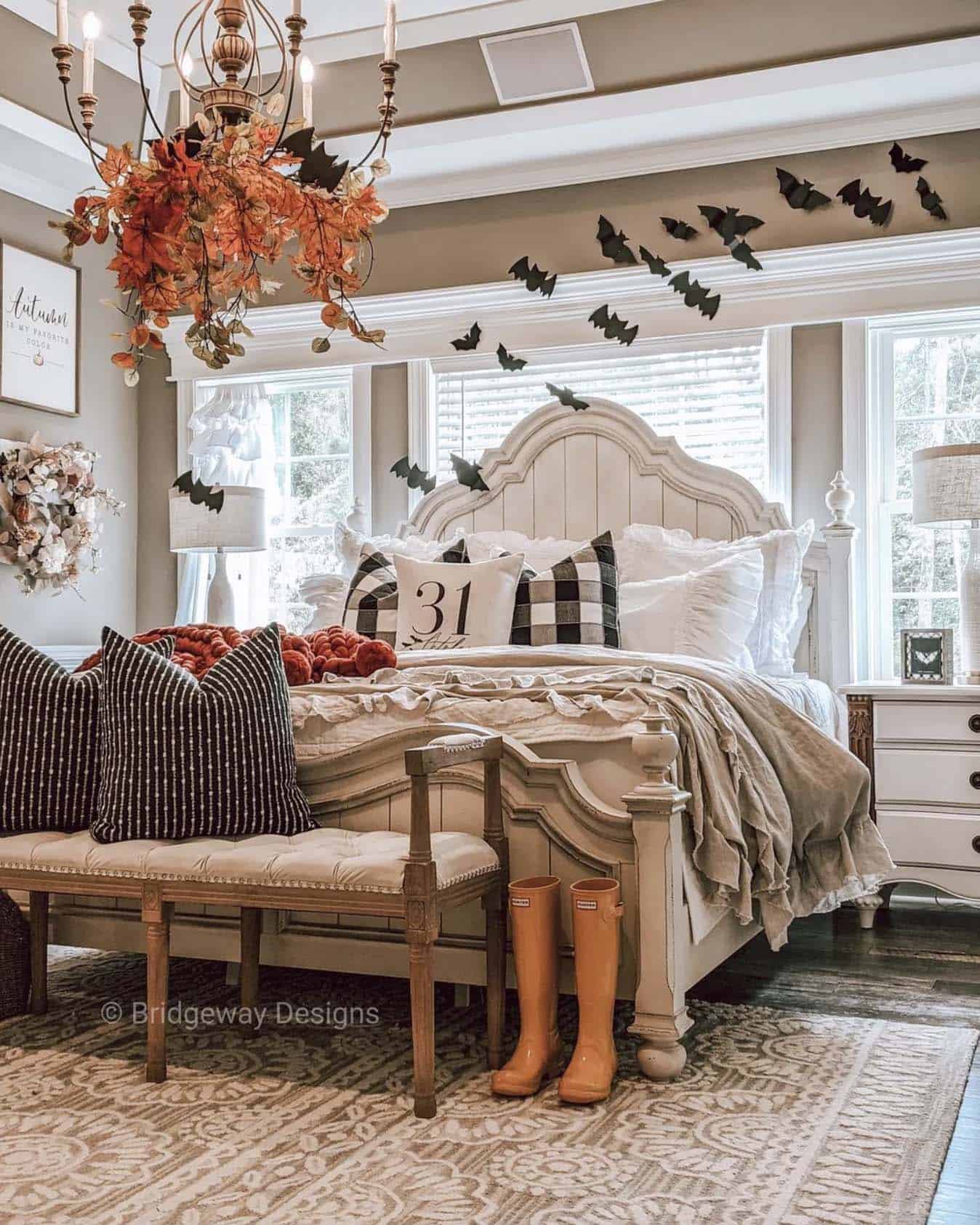 bedroom decorated with a mix of fall and halloween with leaves, pillows and bats on the wall