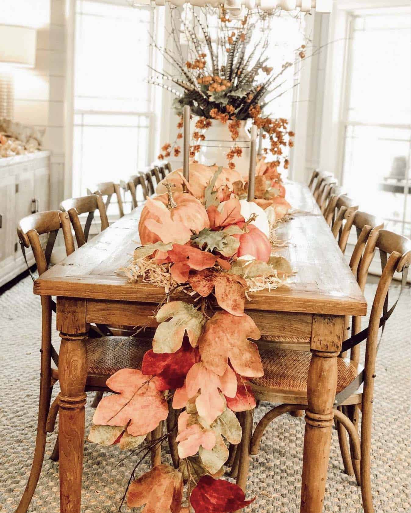 farmhouse style dining room with a leaf garland and pumpkins
