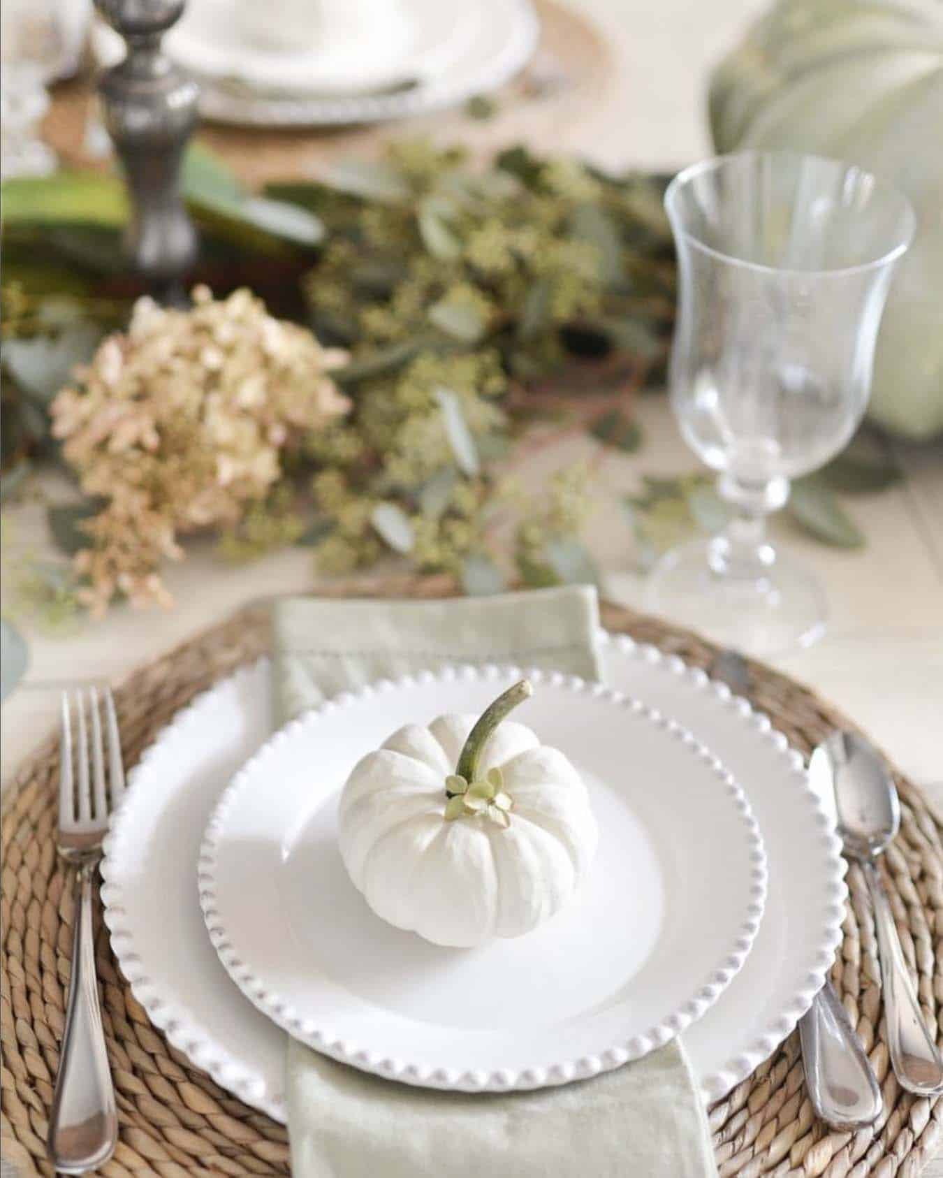fall table setting with white plates and a small white pumpkin