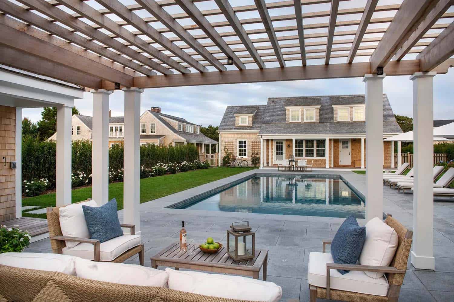 coastal style trellis and outdoor furniture with a view of the swimming pool 