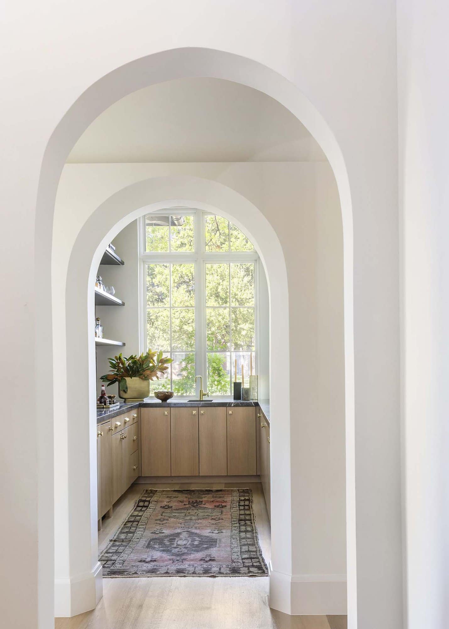 French provincial arched hallway into home bar
