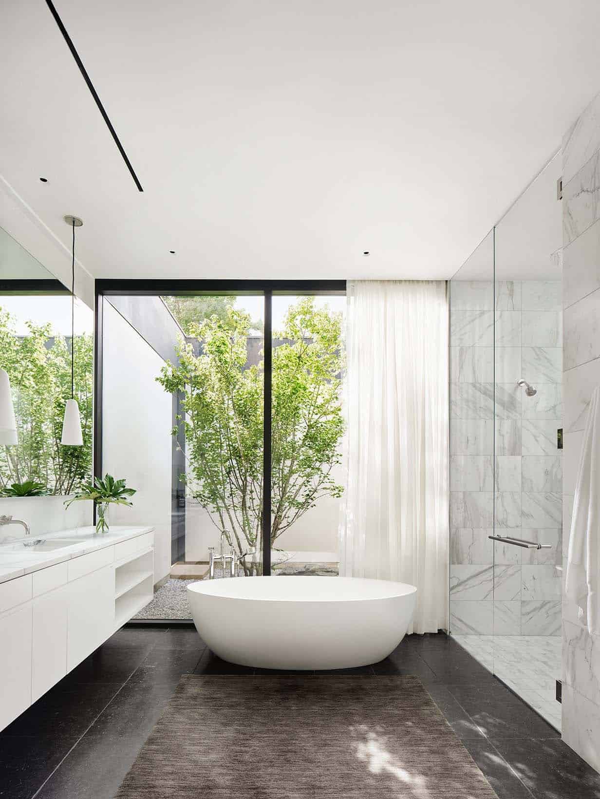modern bathroom with a freestanding tub and views of the interior courtyard