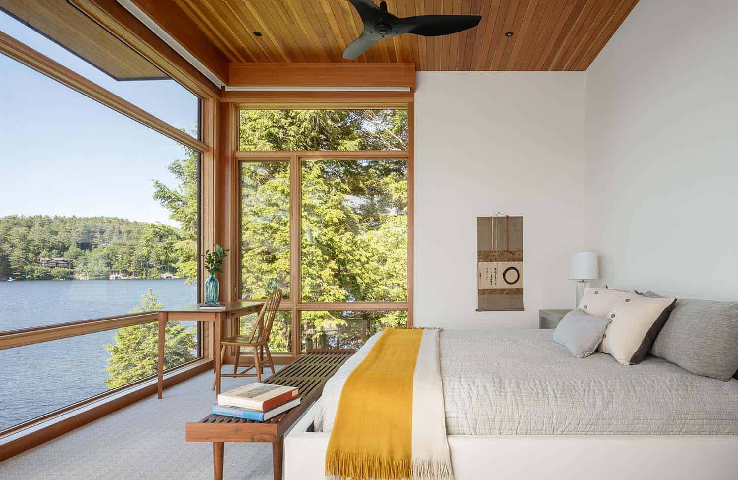 modern bedroom with large windows and lake views