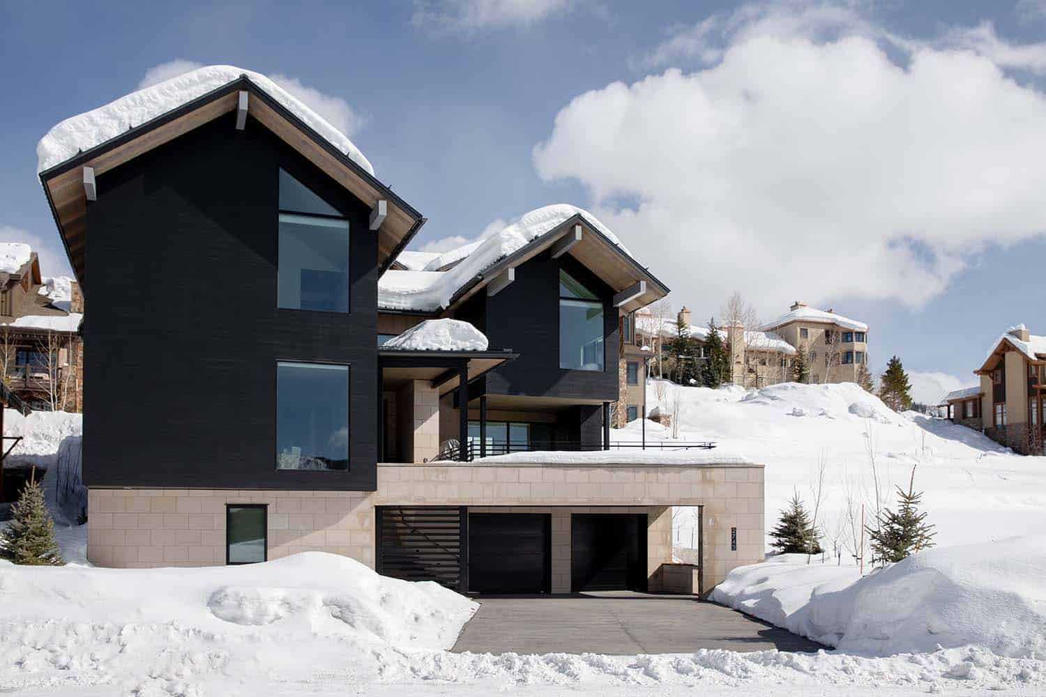 modern mountain lodge exterior with a snowy backdrop