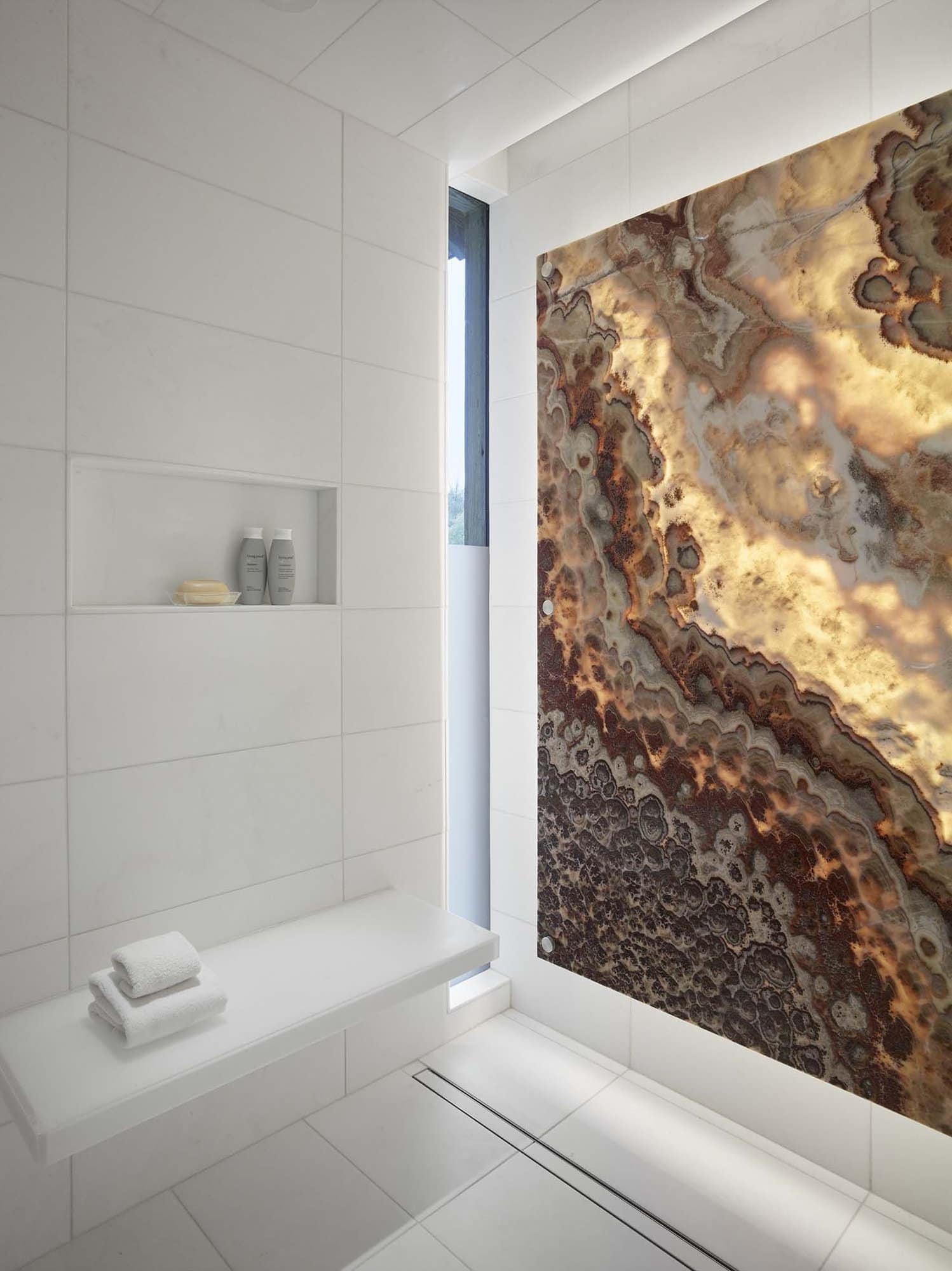 backlit Red River Onyx panel in an all white modern bathroom