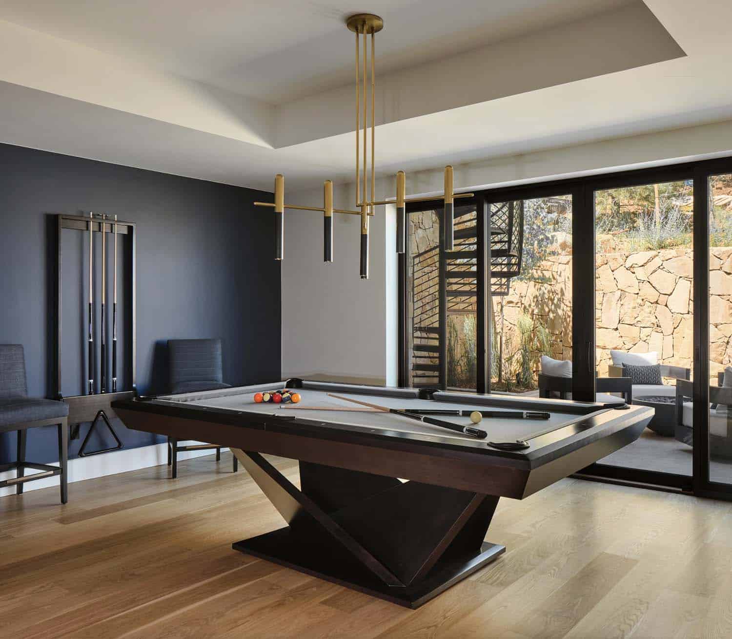 modern basement with a pool table and sliding glass doors leading out to a backyard patio