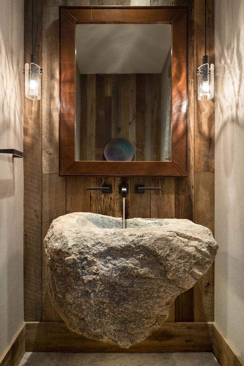 rustic mountain style power room with a stone vessel
