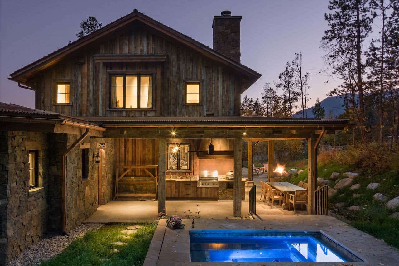rustic mountain home exterior at dusk with a spa