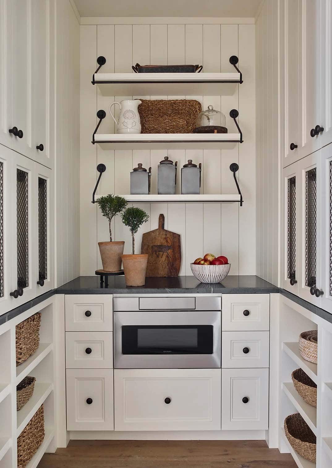 rustic kitchen pantry with a microwave and open shelving