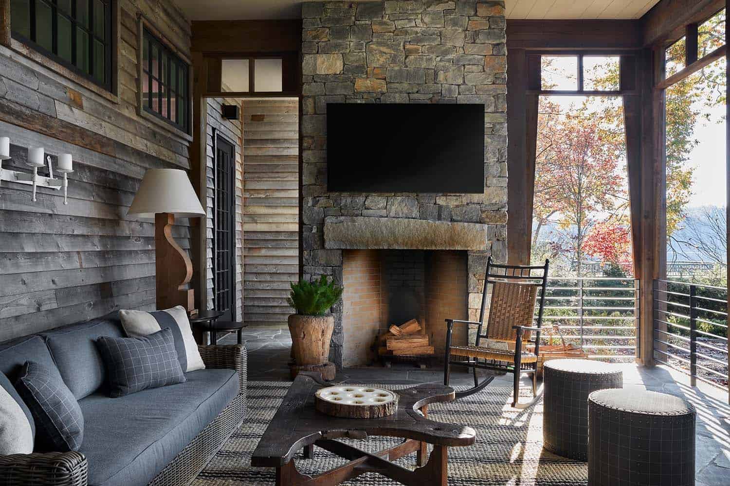 modern rustic screened porch with a stone fireplace