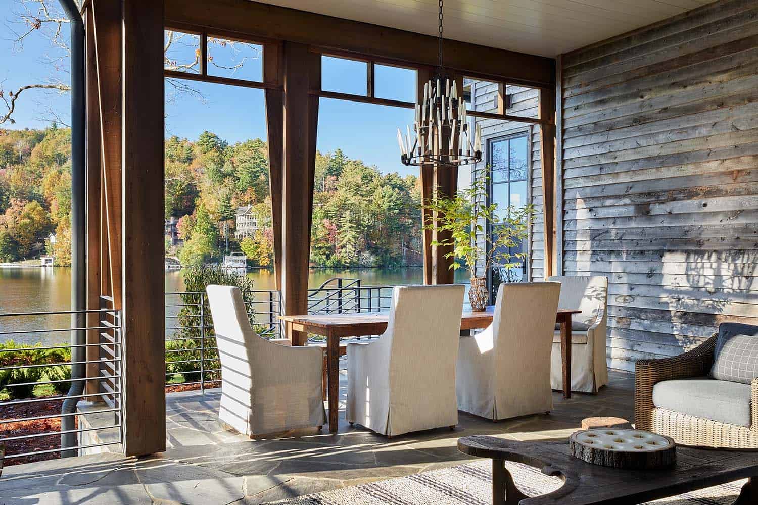 modern rustic screened porch with a dining area overlooking lake toxaway