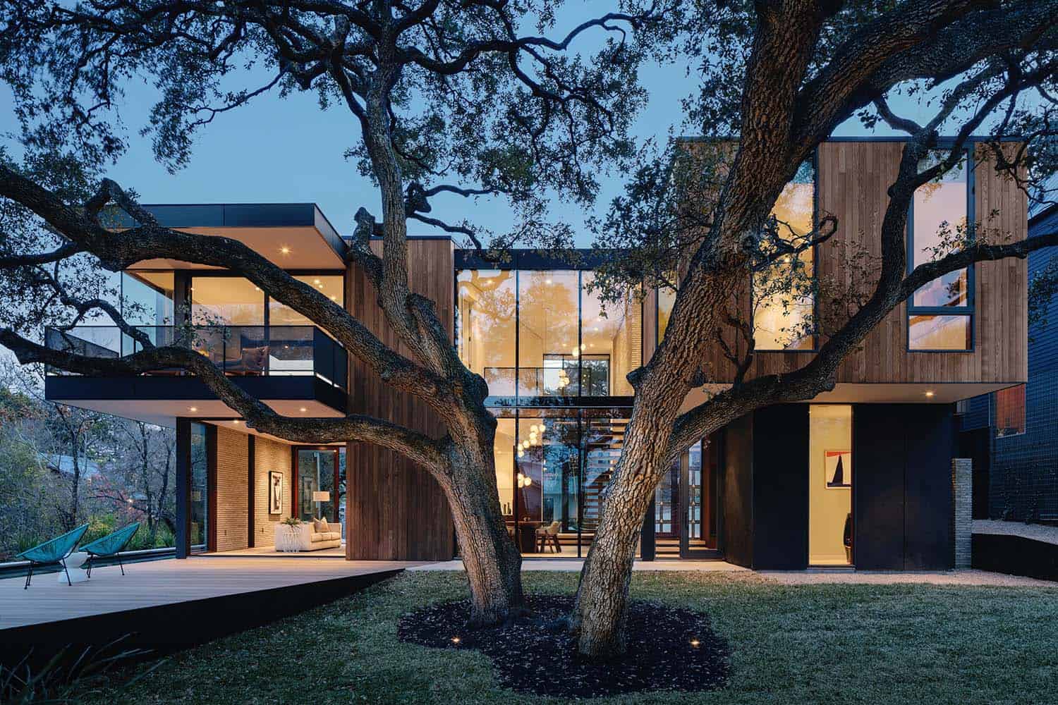 modern home landscape view with a live oak tree at dusk