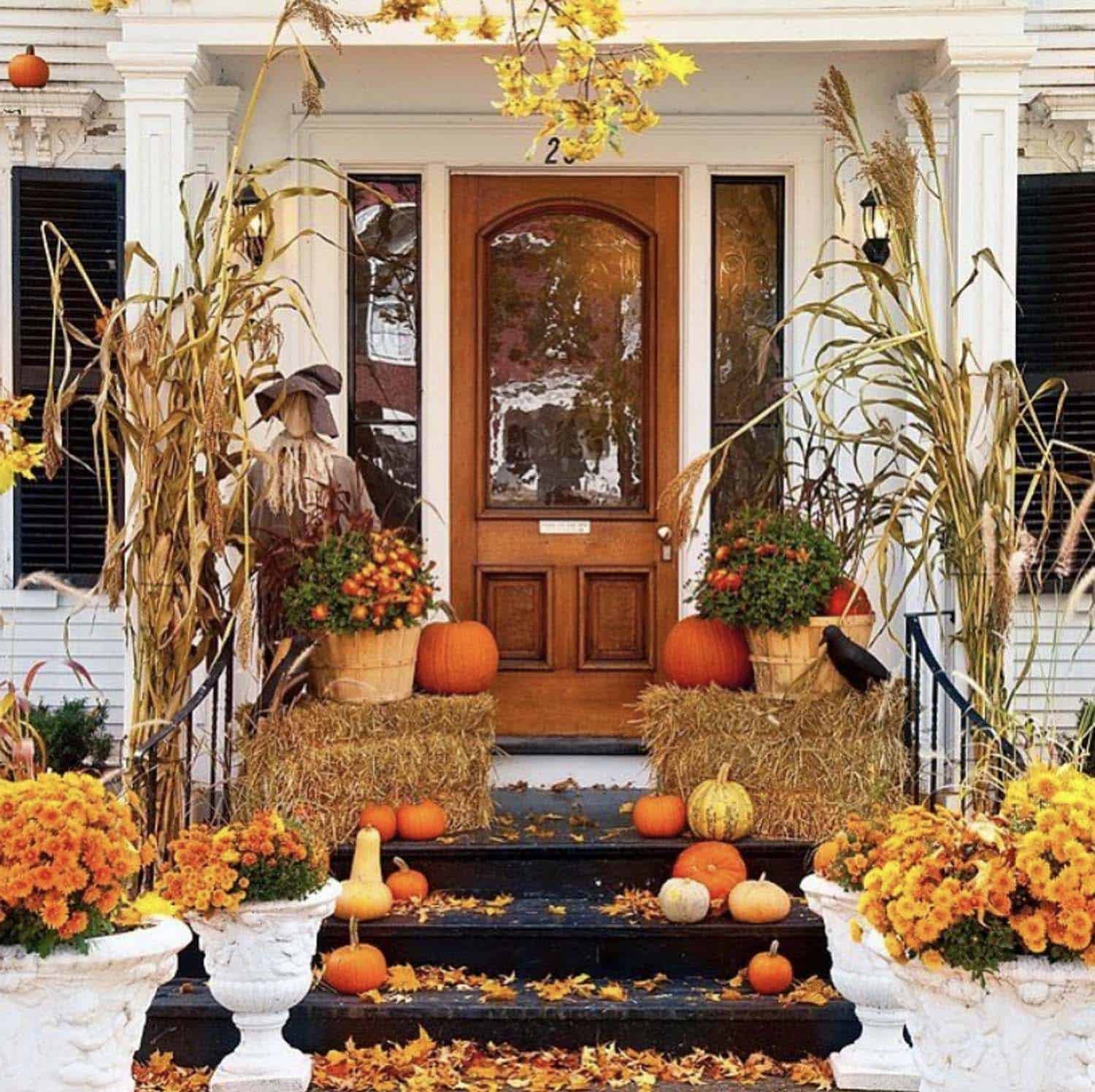 thanksgiving front porch with hay bales, scarecrows and pumpkins