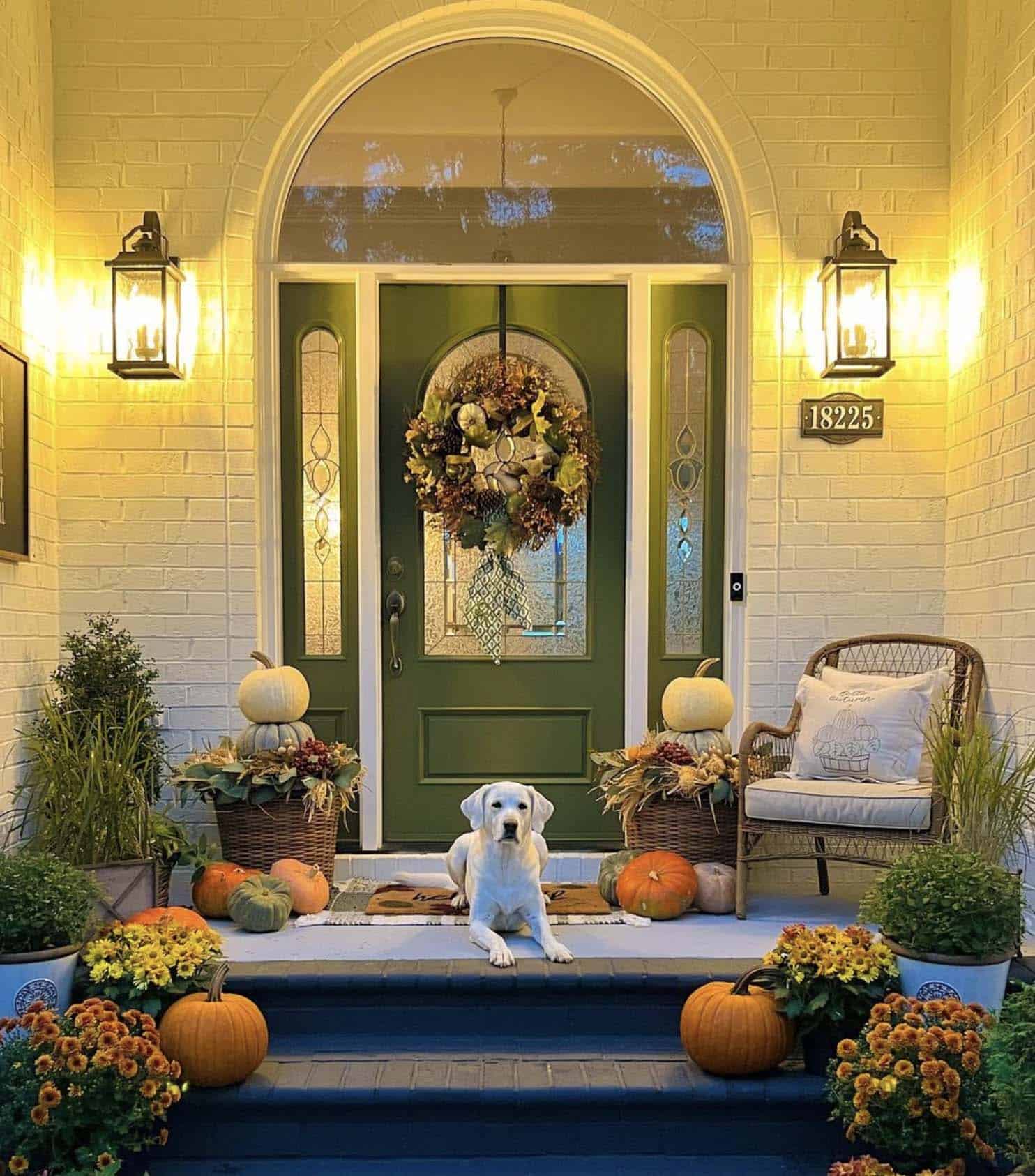 front porch with fall decor and a green painted door