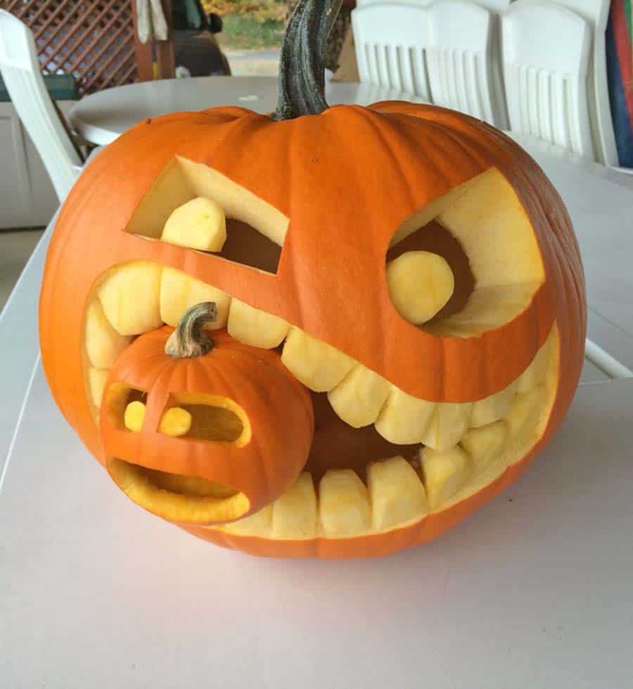 large pumpkin eating a small pumpkin