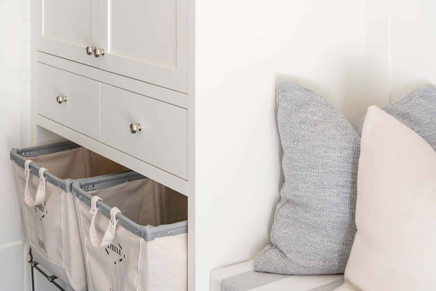 transitional laundry room with a bench and laundry basket storage