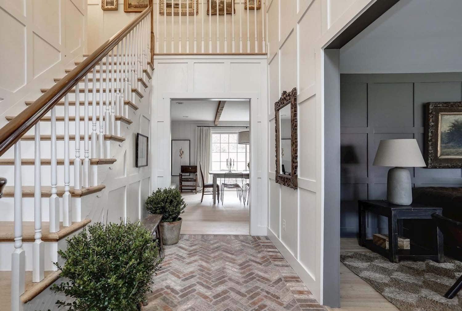 farmhouse foyer with a staircase and herringbone brick flooring