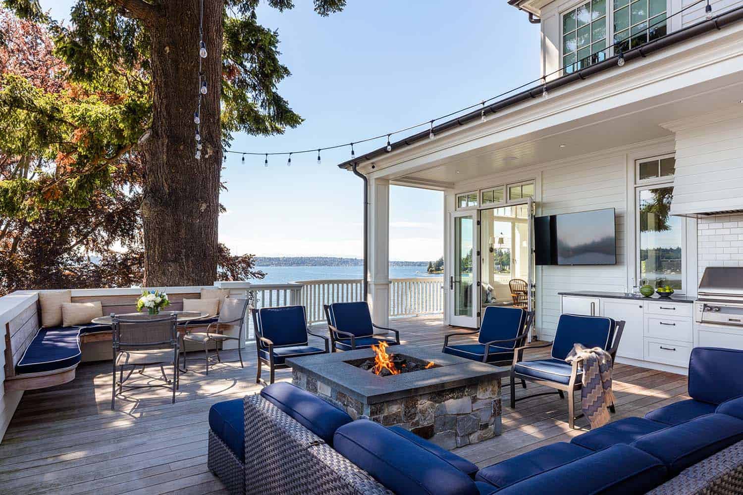 cottage home exterior with a patio and outdoor furniture overlooking the lake