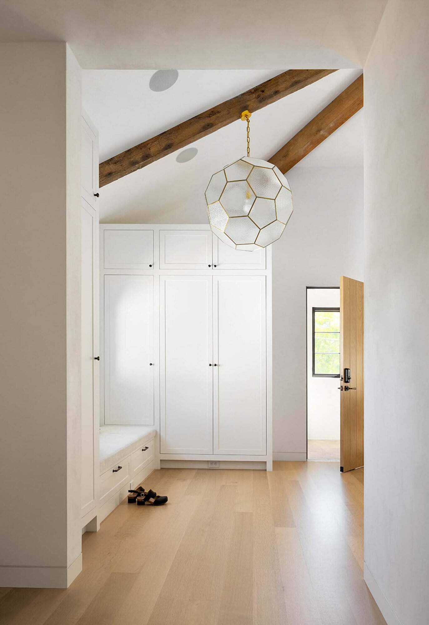 transitional entry with a storage cabinet and large pendant light