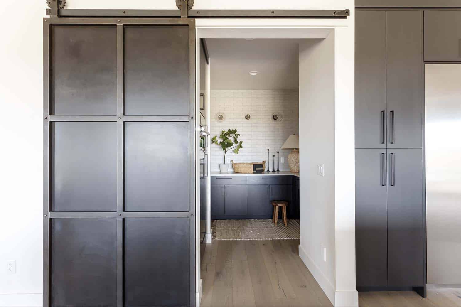 modern sliding barn door leading into the kitchen pantry