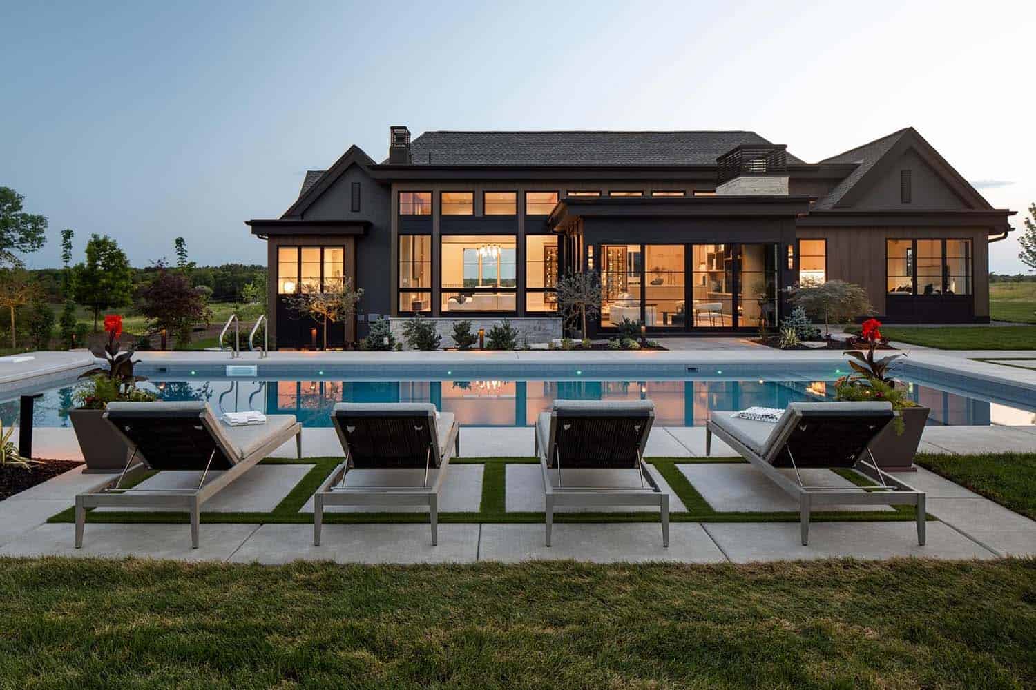 modern rambler home with a swimming pool at dusk