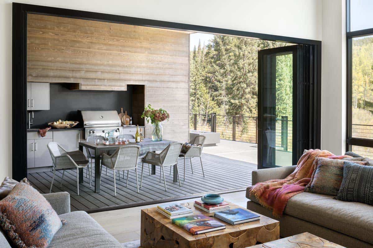 modern family room with sliding glass doors that connects to a covered deck