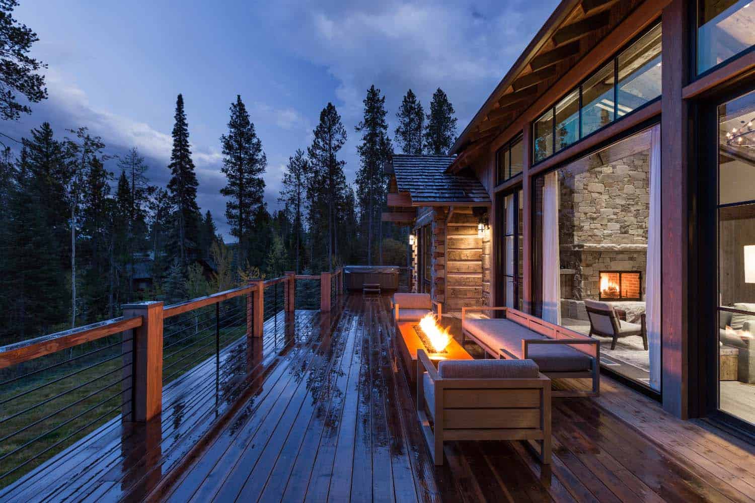 mountain modern cabin retreat deck with a fire pit at dusk