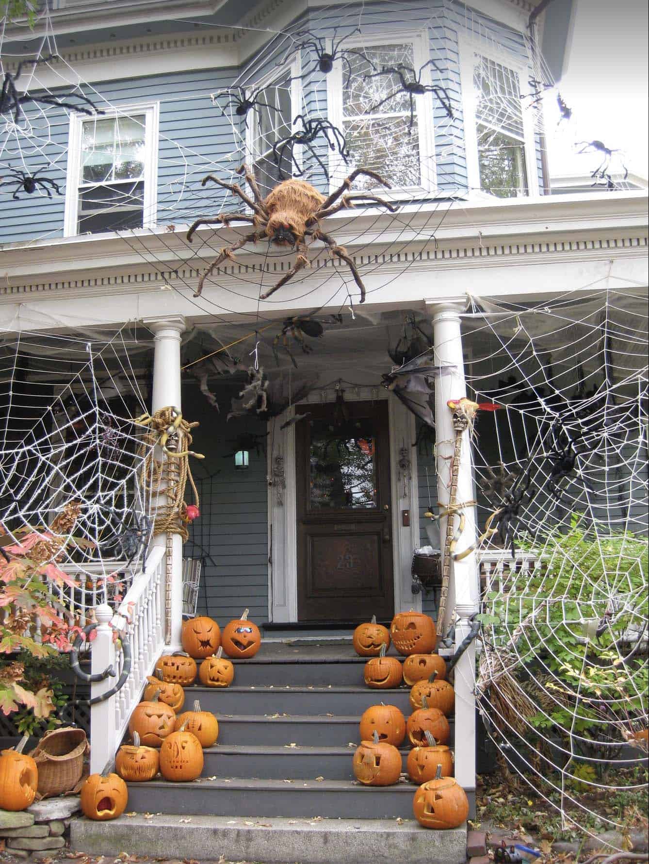 outdoor halloween decorations with spiders and webs and pumpkins