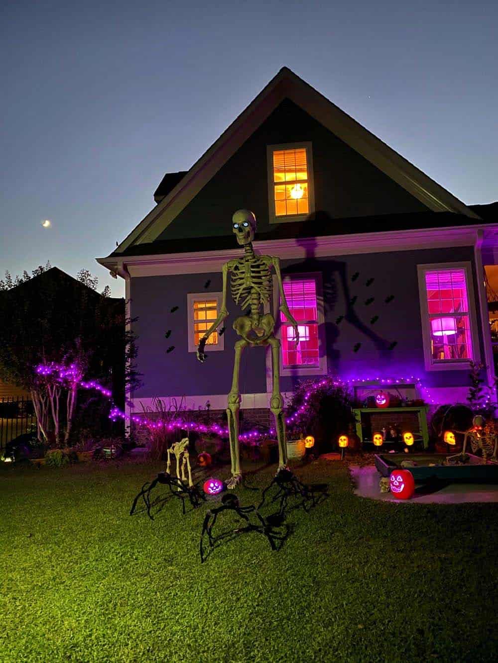 Halloween decorated yard with zombies and skeletons at dusk