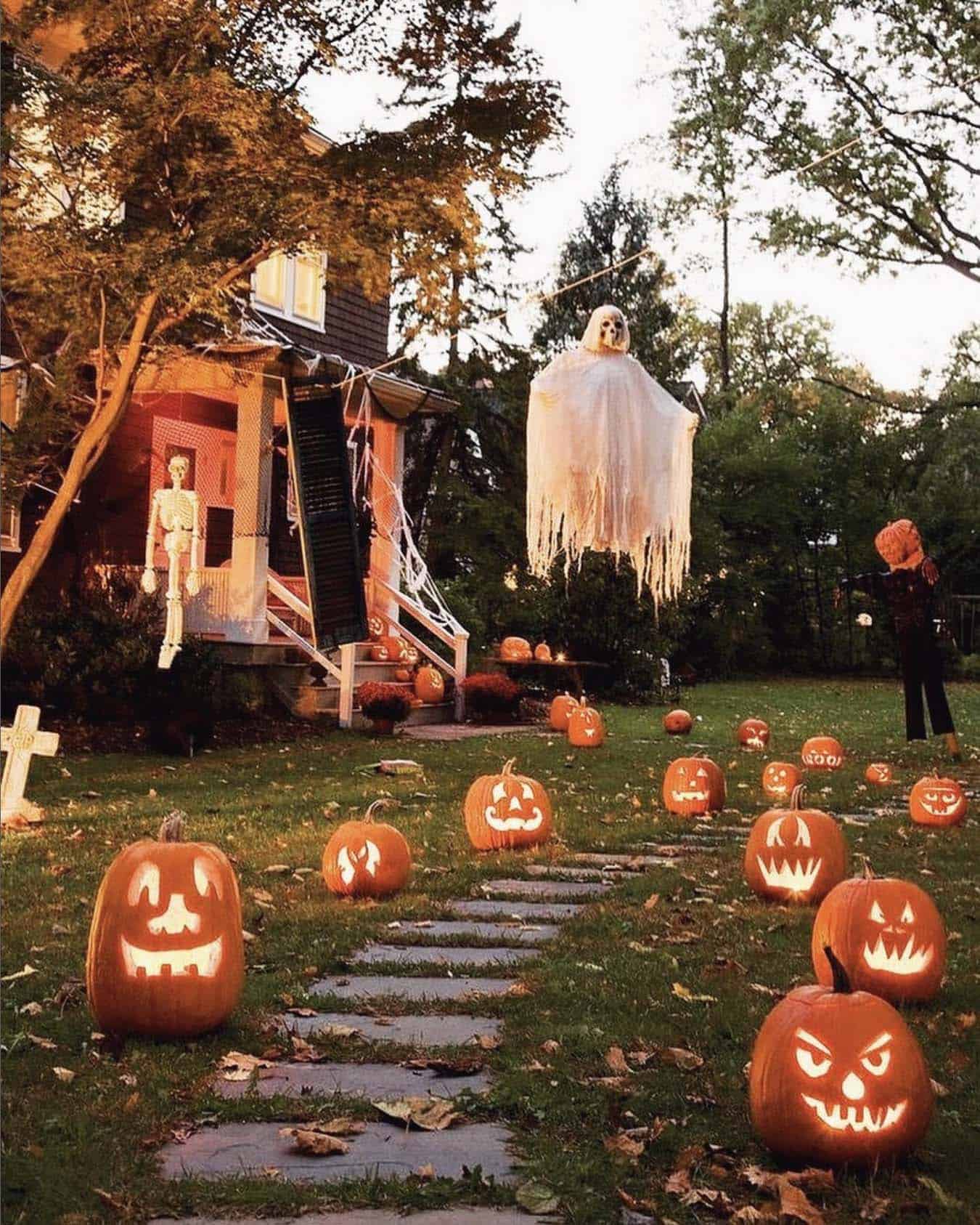 outdoor halloween decorations with pumpkins and ghastly ghosts hanging from the trees