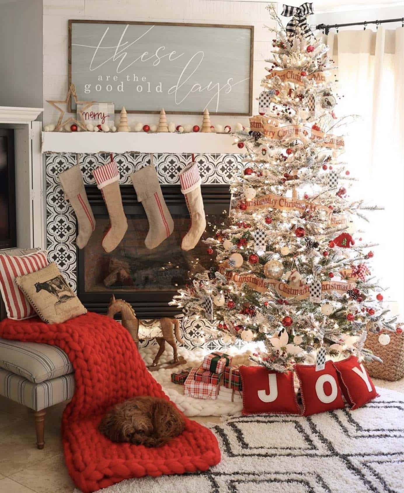 fireplace accented with a flocked tree, JOY pillows, and a chunky red blanket