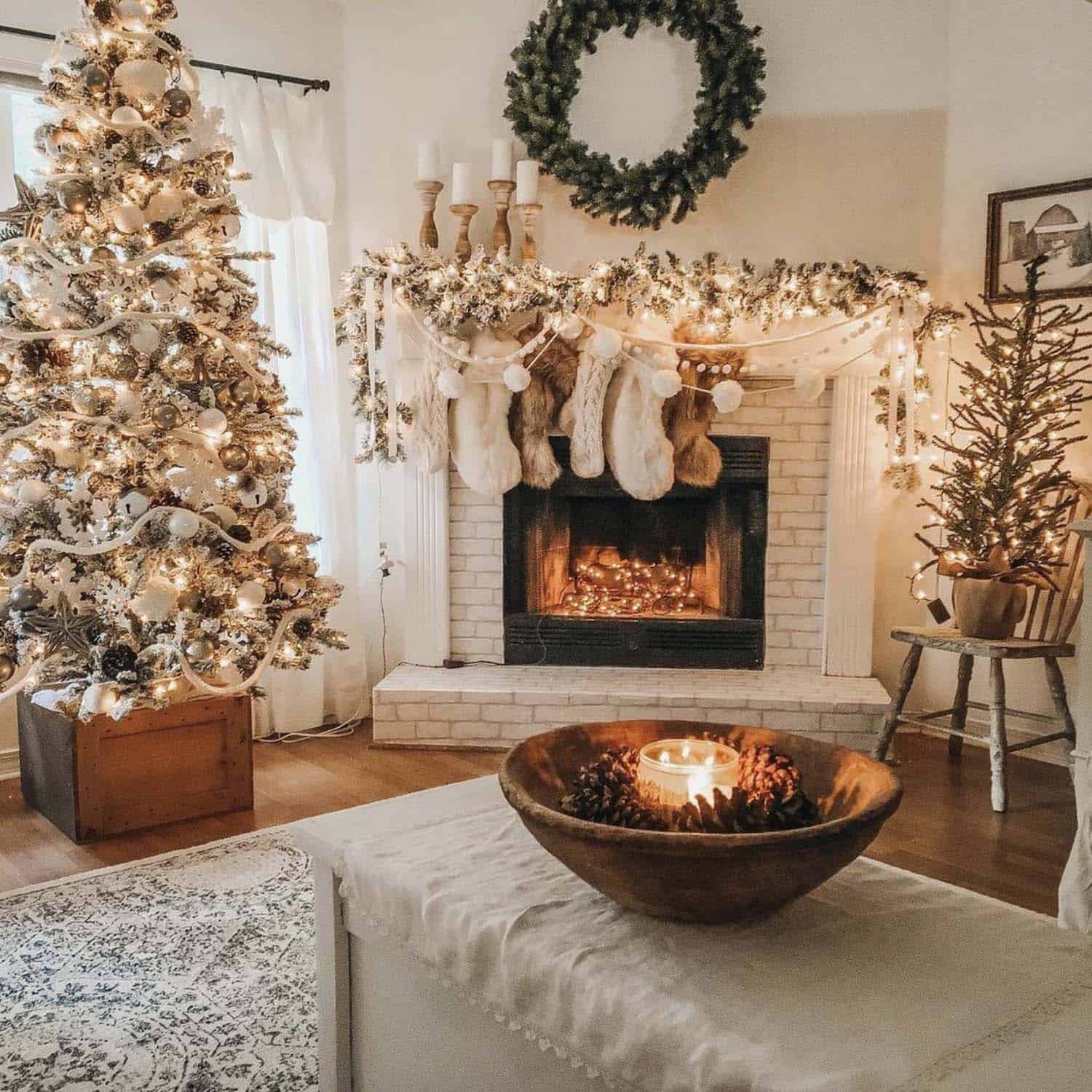  cozy family room with a flocked Christmas tree and garland on the fireplace mantel with stockings and candles