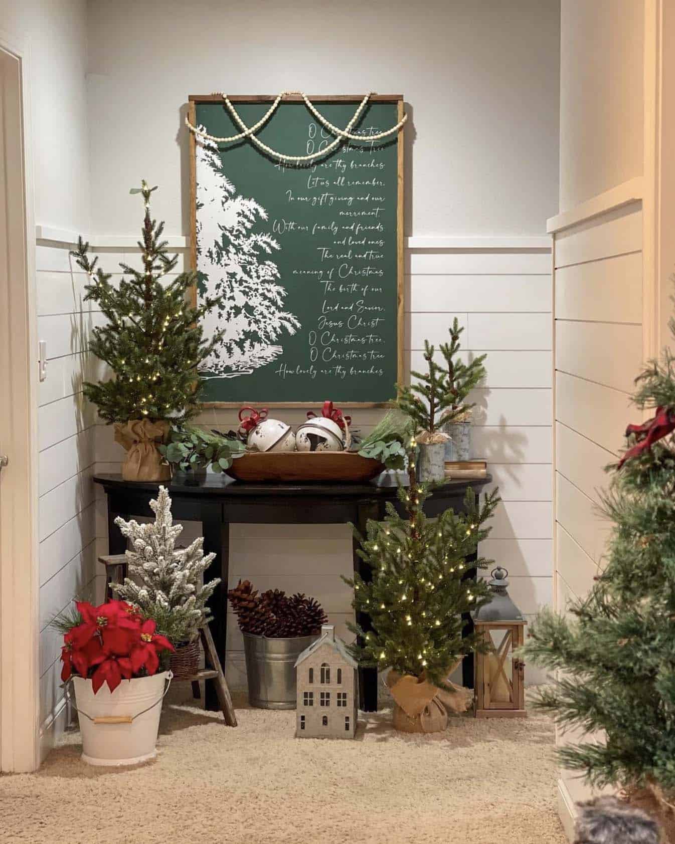 hallway decorated with a large Christmas sign, trees, and giant bells in a dough bowl