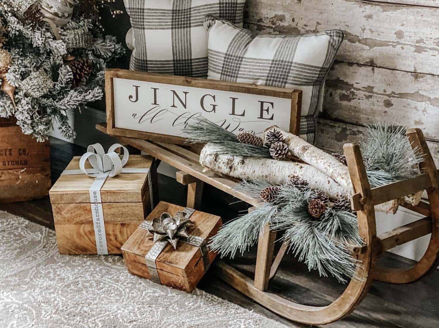 a sled with a Christmas sign, fire logs, garland, and wooden presents