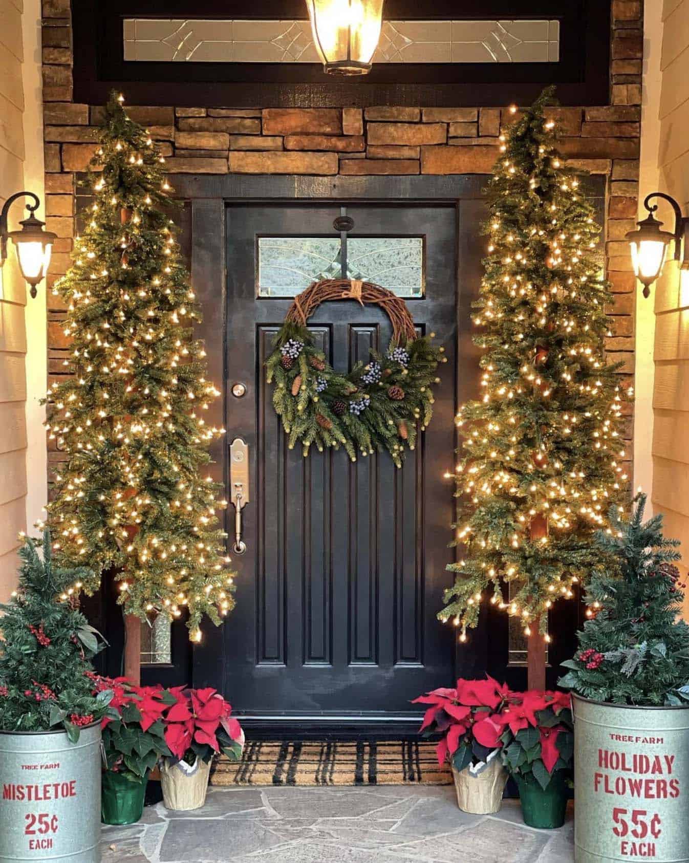 Christmas decorated front door with a garland, wreath and poinsettias