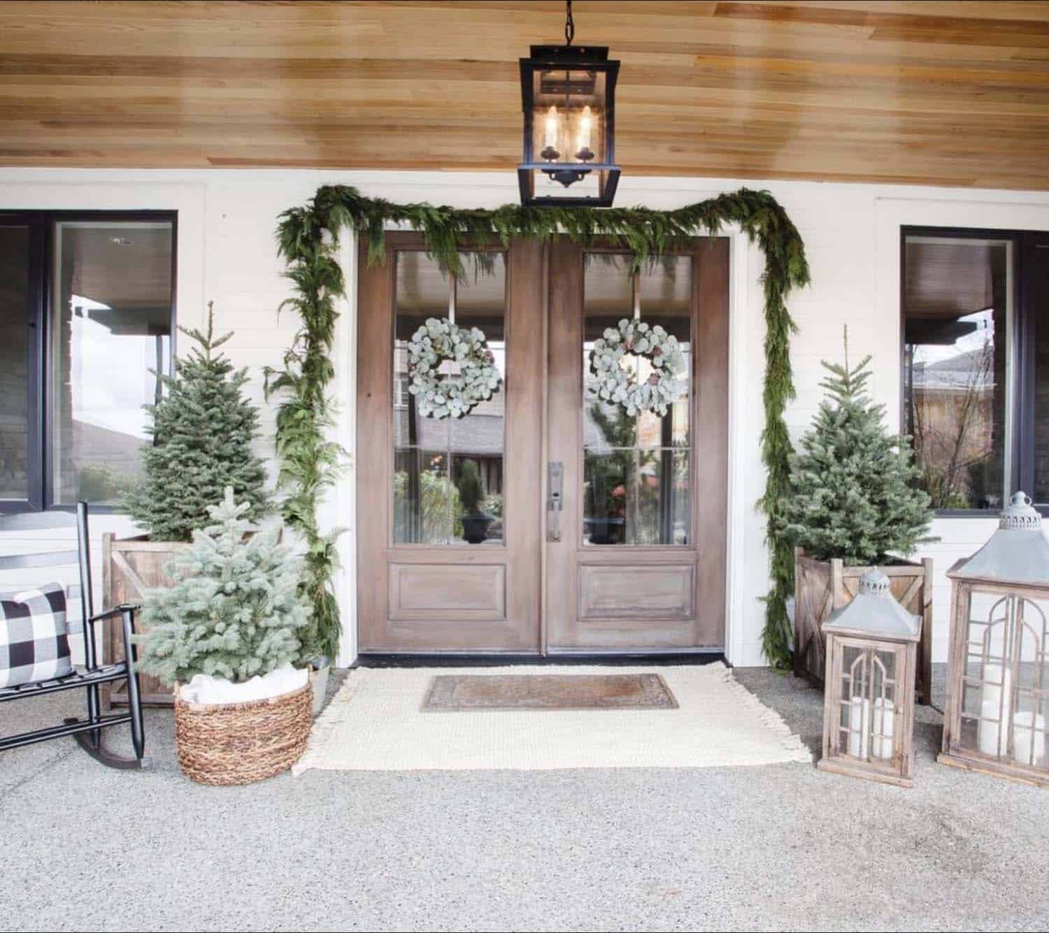 Christmas decorated front porch with garland and noble fir trees