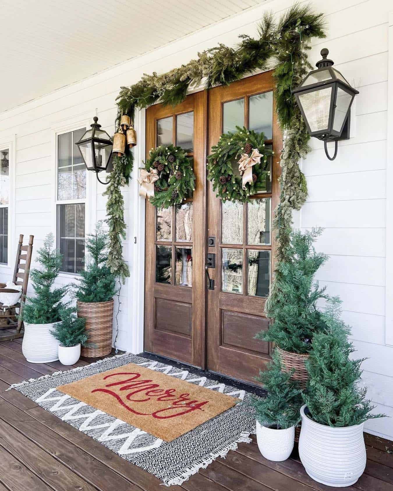 warm and inviting Christmas entry with wreaths, garland and mini trees